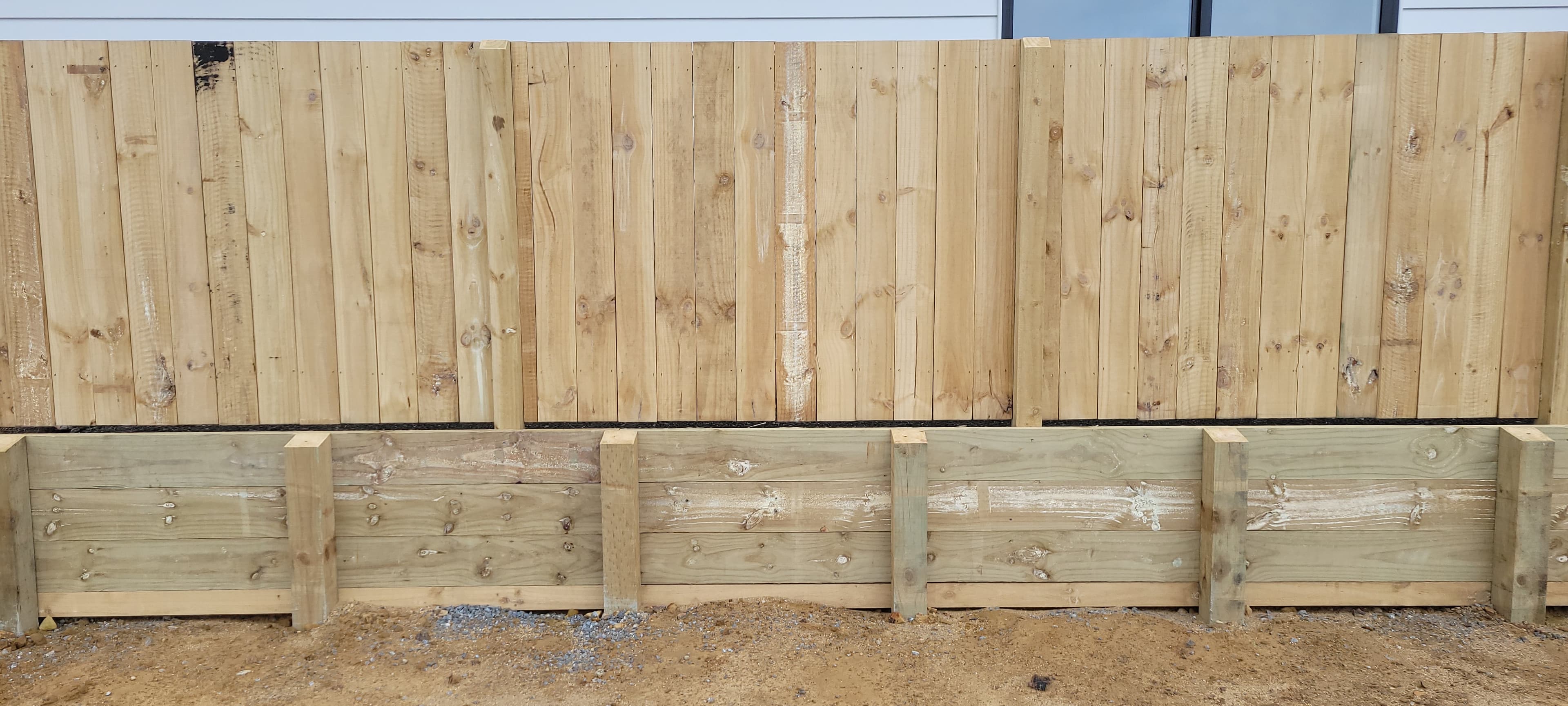 Completed timber privacy fence on a low sleeper retaining wall in Wellington